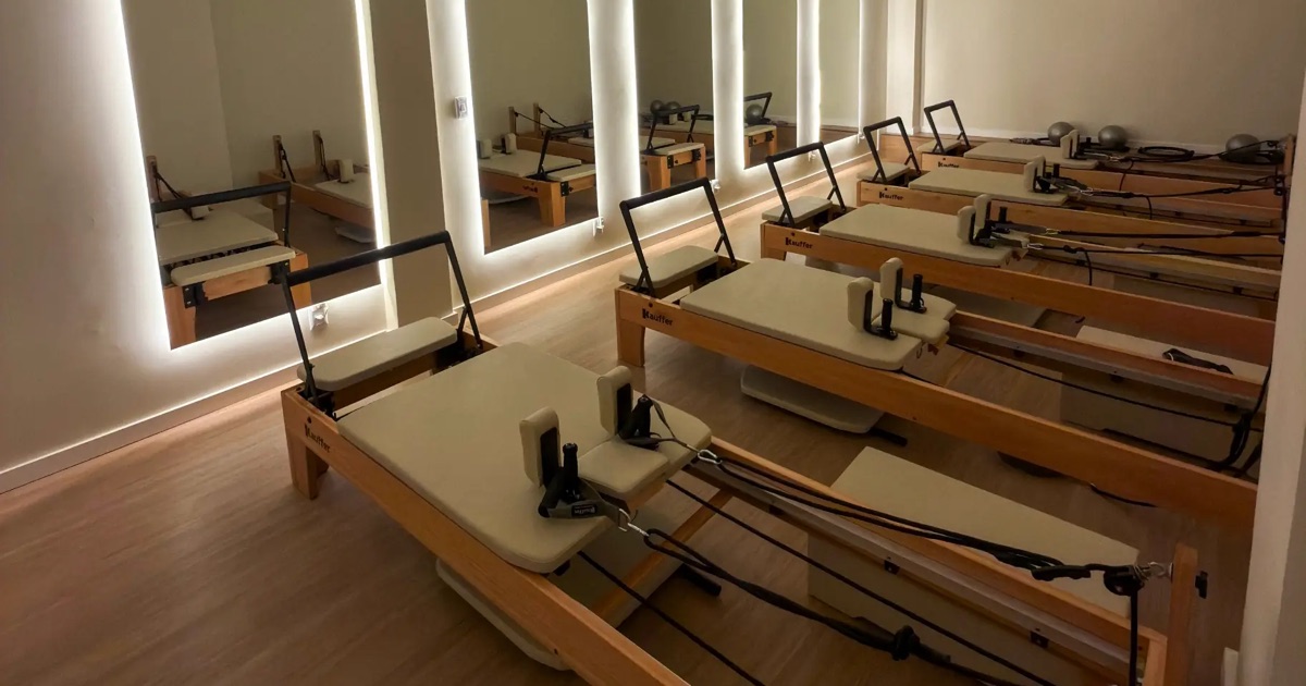 Aparelhos de Pilates Reformer lado a lado no estúdio da FLUX Club, no Buritis